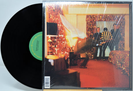 Vinyl record with a cover featuring a band in a room setting.