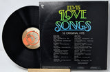 Vinyl record with 'Elvis Love Songs' album cover on a white background