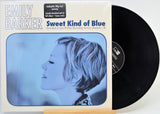 A vinyl record album for Emily Barker's 'Sweet Kind of Blue' with the cover art showing a blue-toned profile photo of the artist and a partially visible black LP record behind it.