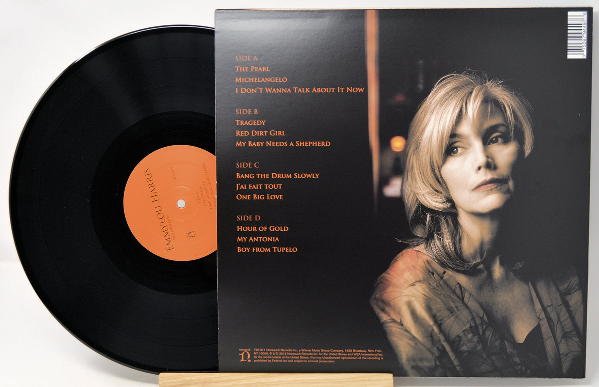Vinyl record LP shown with the back cover and part of the black record disc. The cover features a portrait of a woman on the right and a track list printed in orange text on the left, photographed against a light neutral background.