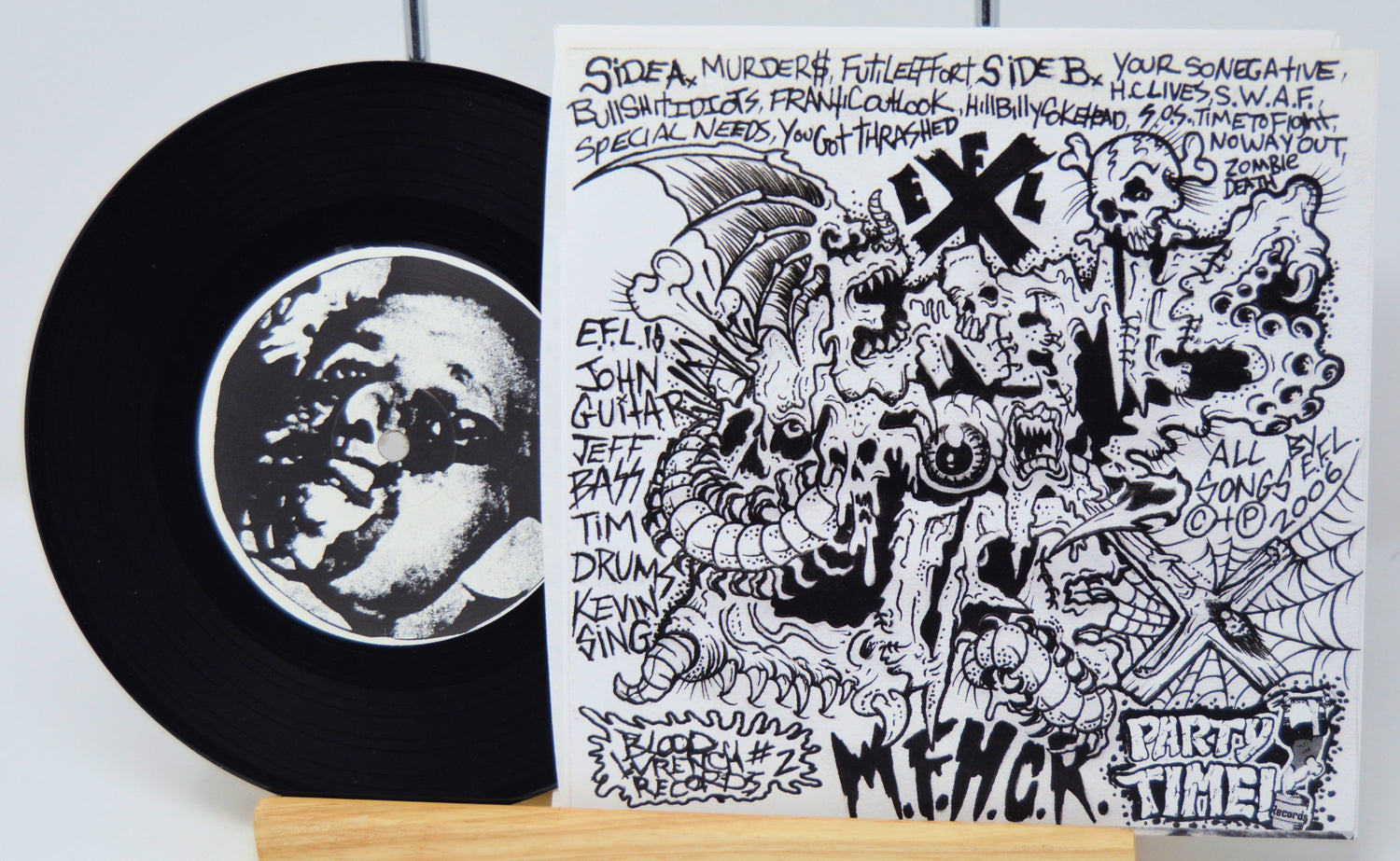 Vinyl record with a black and white cover featuring graphic designs and text.