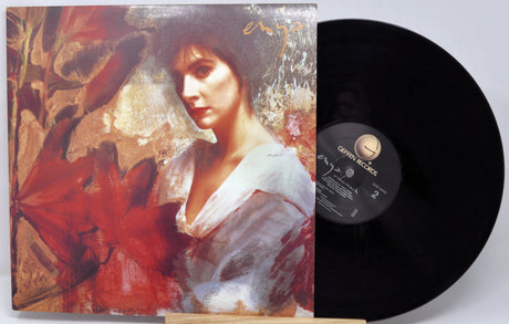 Vinyl record with a colorful cover featuring a woman's portrait and a red flower.