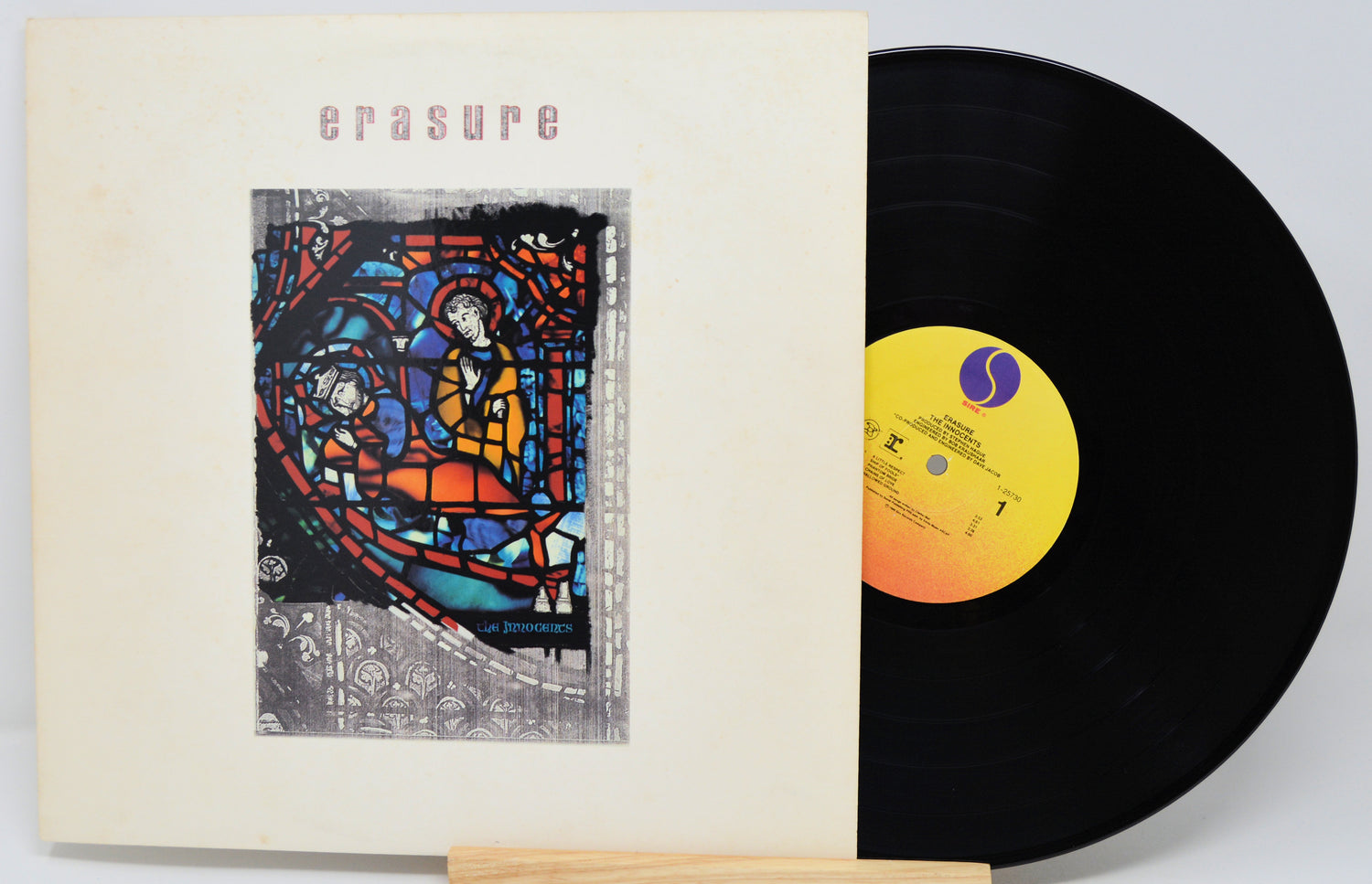 Vinyl record and cover with stained glass design and 'erasure' text