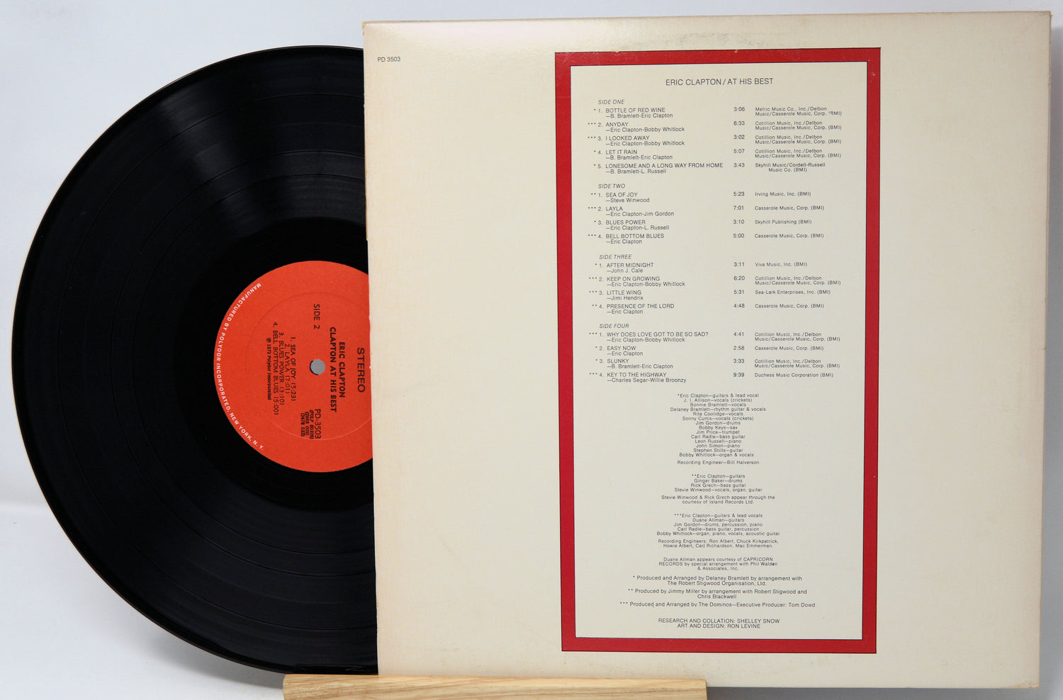 Vinyl record with red label and matching cover on a light gray background