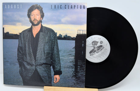 Vinyl record with cover featuring a man by a waterfront, 'Eric Clapton' album text.