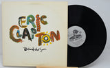 Vinyl record and cover with 'Eric Clapton Behind the Sun' on a white background