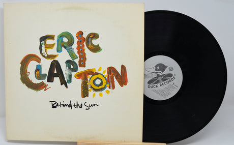 Vinyl record and cover with 'Eric Clapton Behind the Sun' on a white background