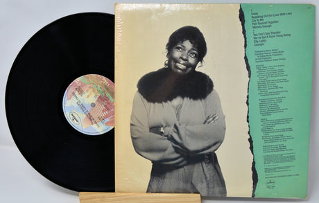 Vinyl record with cover featuring a person, visible text, and colorful label.