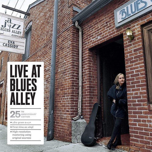 Woman standing in the doorway of a brick building with 'Blues Alley' sign, promotional poster for 'Live at Blues Alley' on left.
