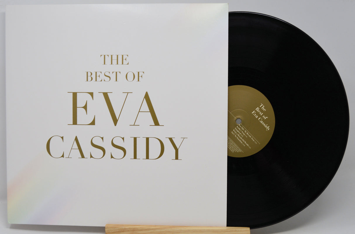 The Best Of Eva Cassidy vinyl record album with the white cover and black record partially visible on a stand against a light gray background.