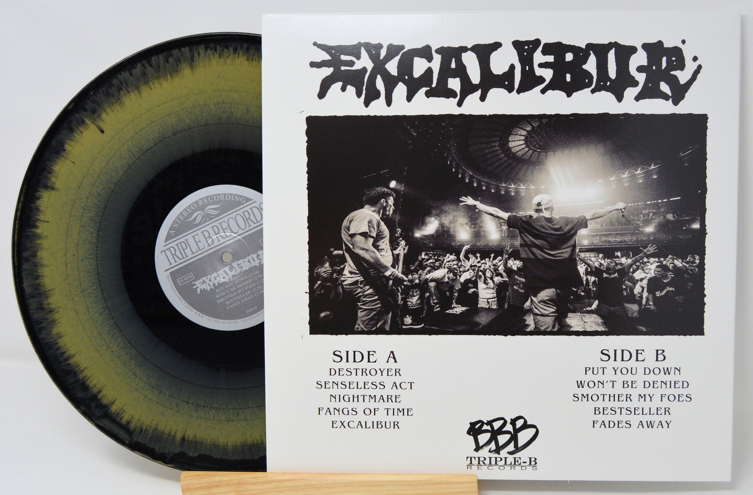 Excalibur vinyl record with black and yellow splatter, album tracklist and live concert photo on Triple-B Records cover