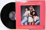 Vinyl record with a pink cover featuring three women and text.
