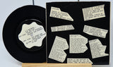 Vinyl record with a black cover featuring white text and labels.