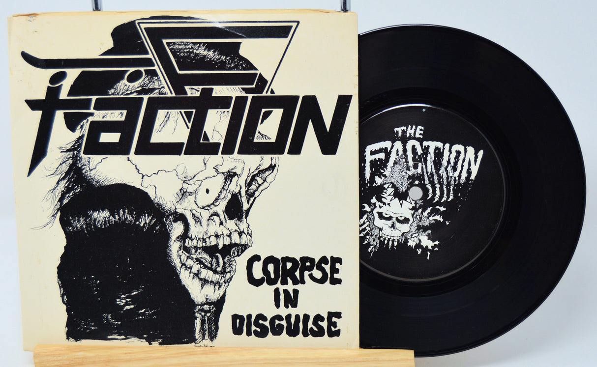 Vinyl record with 'The Faction' cover featuring a skull and text.