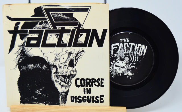 Vinyl record with 'The Faction' cover featuring a skull and text.