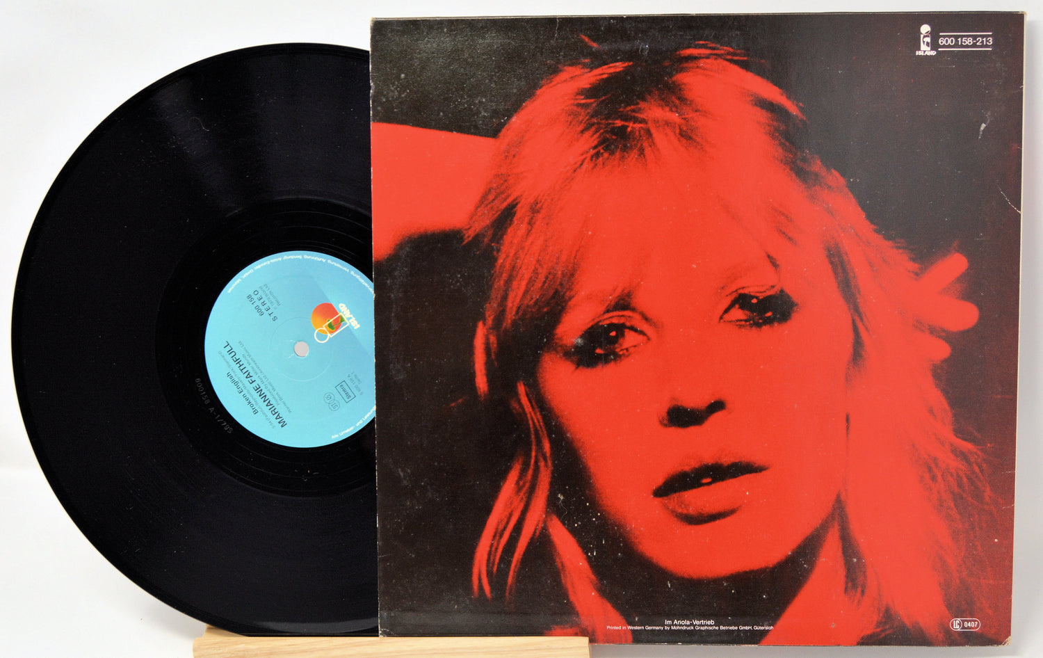 Vinyl record with a red and black cover featuring a stylized portrait.