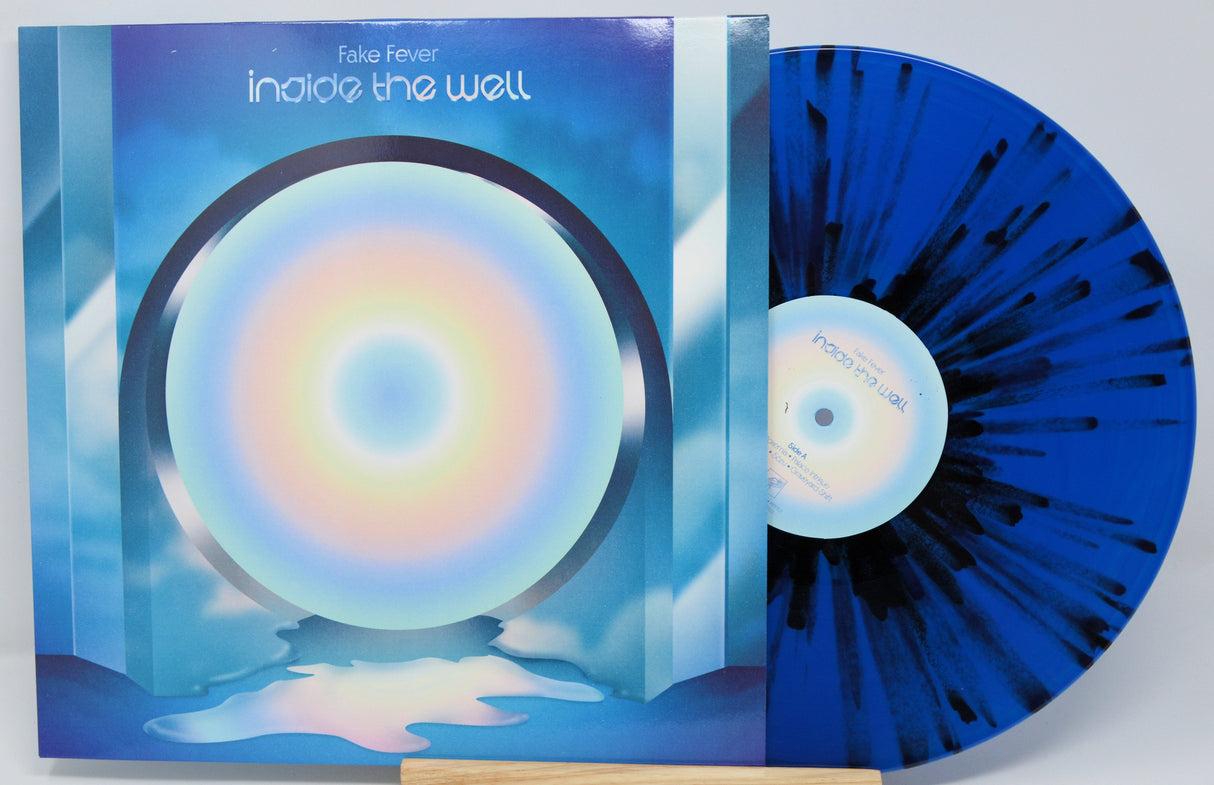 Front cover and blue splatter vinyl record of Fake Fever's Inside the Well featuring circular rainbow artwork