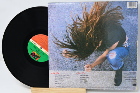 Vinyl record with a colorful label and a person with long hair on the cover