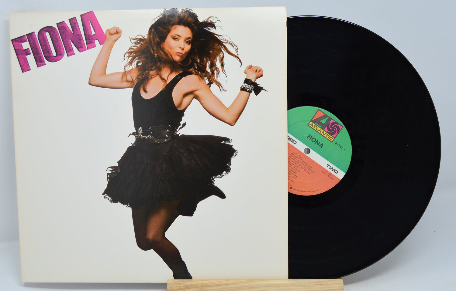 Used vinyl record album cover featuring a woman in a black dress dancing. The album title 'Fiona' is displayed at the top in pink text, and the record label 'Atlantic' is visible.