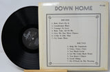 Vinyl record with cover displaying tracklist on a light gray background