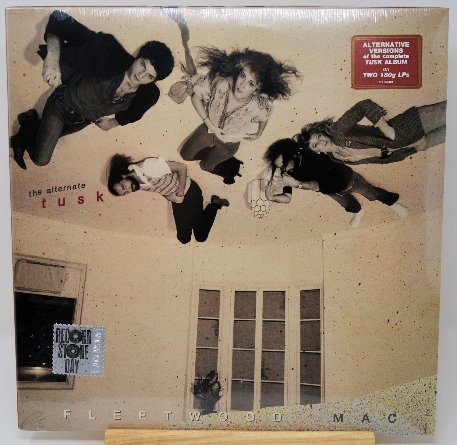 Fleetwood Mac - The Alternative Tusk vinyl record album, sealed in its original shrink wrap. The cover art features a beige-toned illustration of four people floating in the air above a house with windows.