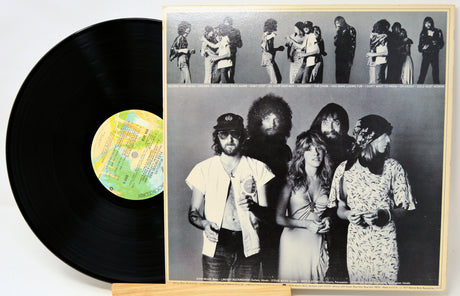 Vinyl record with a cover featuring a group of people, including a prominent person holding a guitar.