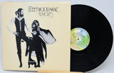 Vinyl record with 'Fleetwood Mac Rumours' cover showing two figures.
