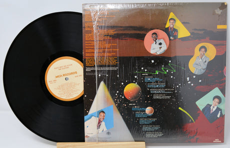 Vinyl record with cover featuring space-themed design and images of a person.