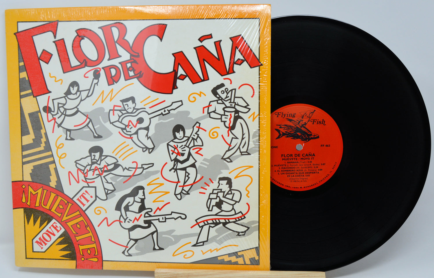 Vinyl record with colorful cover featuring dancing figures and text.