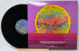 Vinyl record with a colorful cover featuring text and graphics on a white background