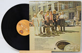 Vinyl record with a cover featuring a group of people outdoors.