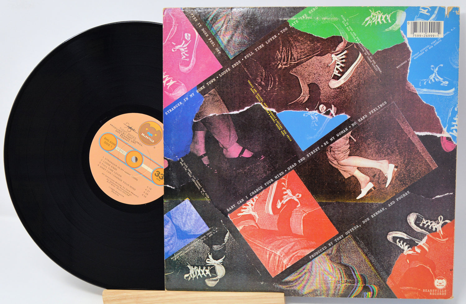 Vinyl record with colorful cover featuring artistic designs on a light gray background