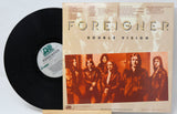 A used vinyl record of Foreigner's album 'Double Vision' with the band members pictured on the  back cover with text for the song titles.