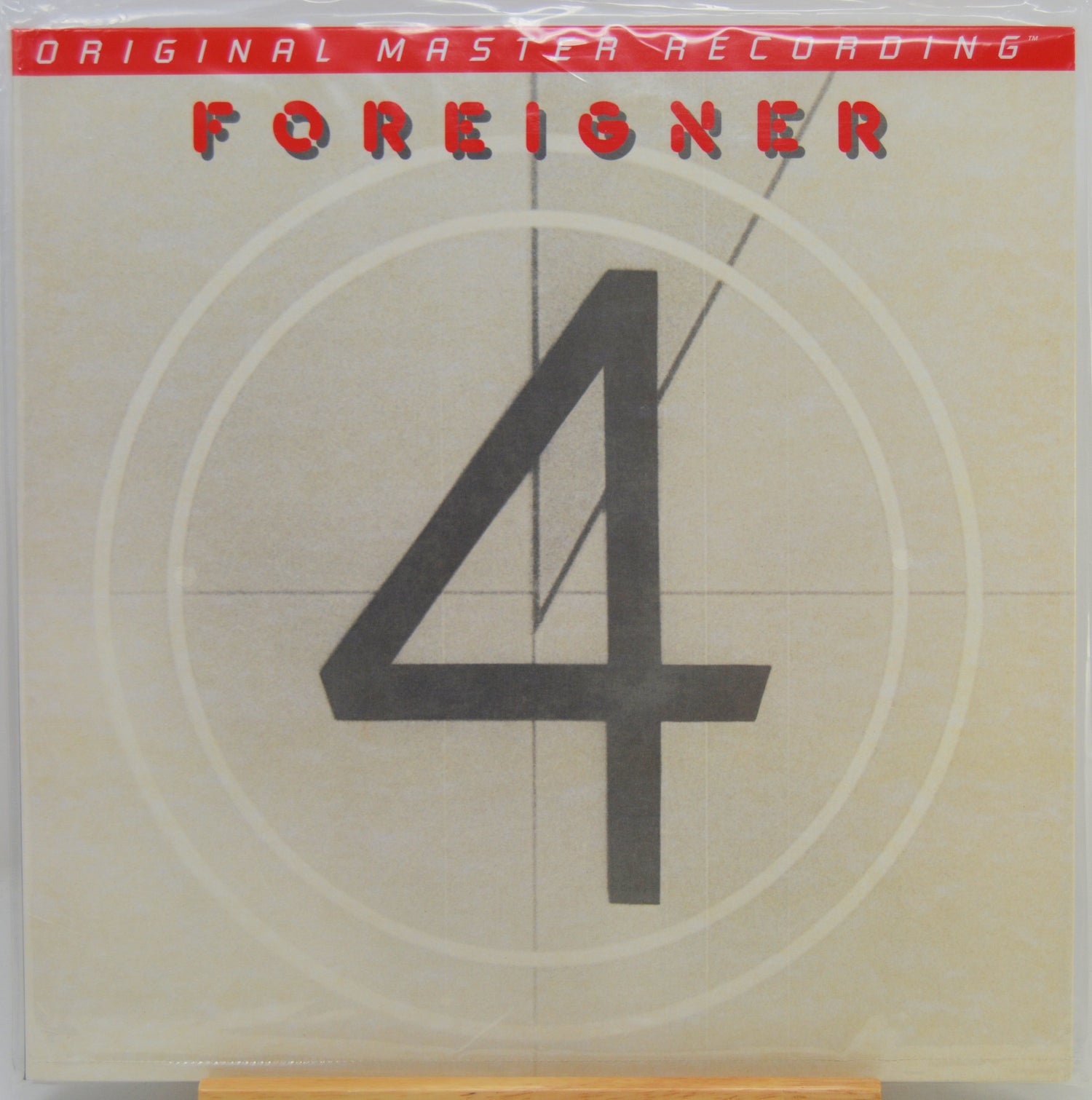Foreigner '4' original master recording album cover, featuring a large black number 4 on a beige background with a red banner at the top.
