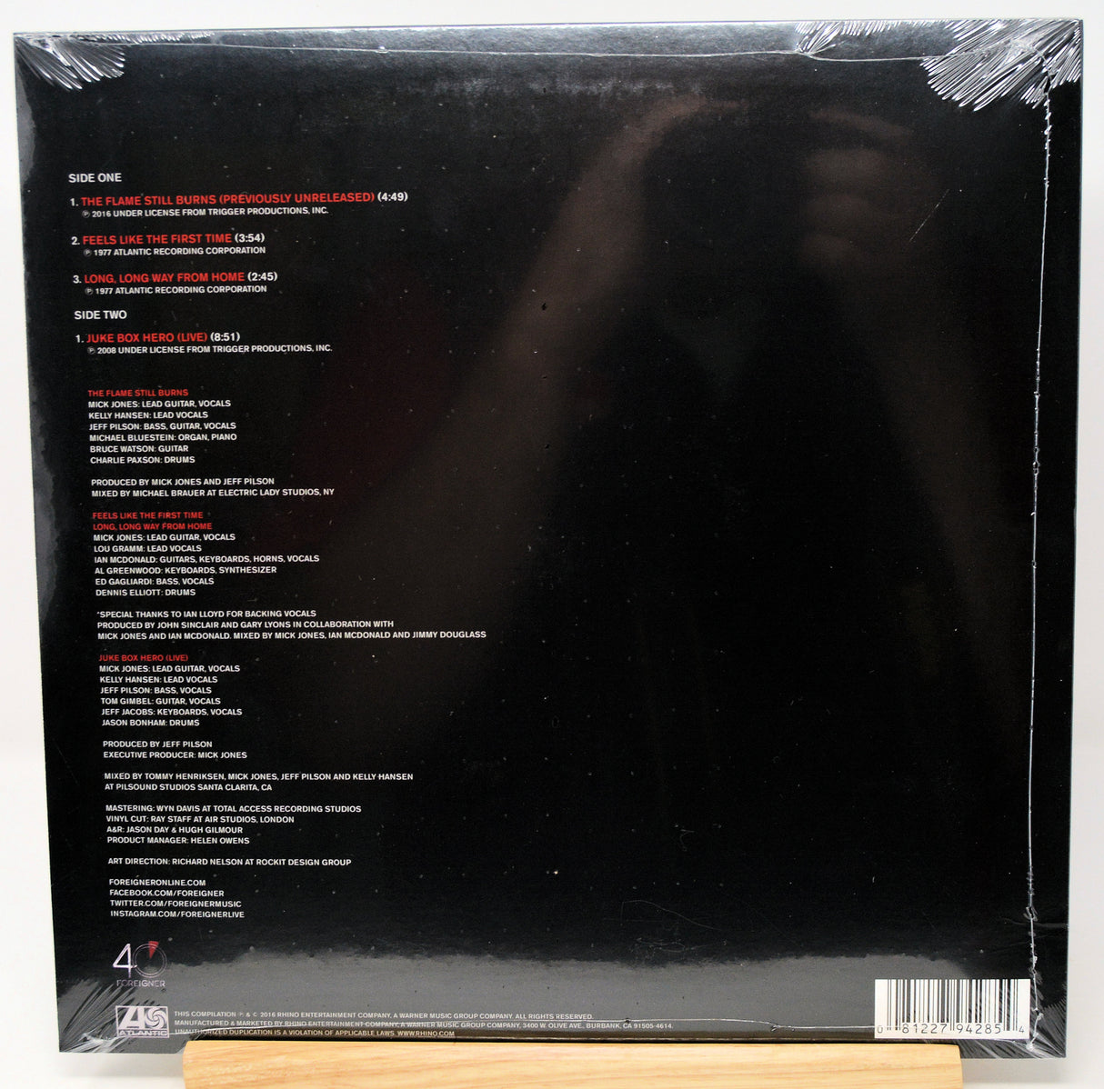 The back cover of a vinyl record album, sealed in plastic shrink wrap, showing track listings and credits on a black background with a barcode and 470GB logo.