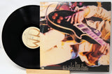Peter Frampton Comes Alive! Vinyl record with a colorful cover featuring a person playing a guitar and song listing in text