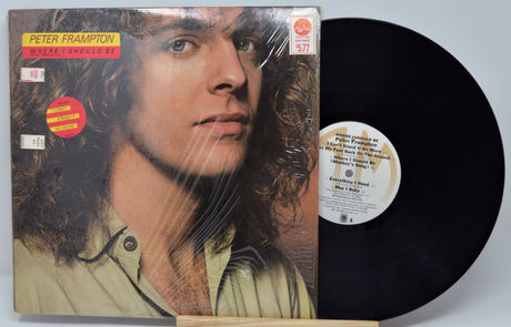Vinyl record with cover featuring a person's face, on a light gray background