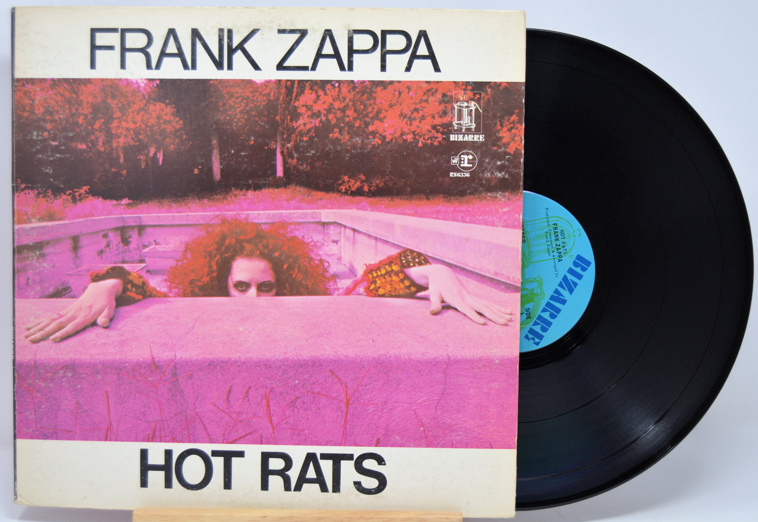Vinyl record with 'Hot Rats' by Frank Zappa on a pink and purple album cover.