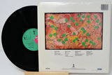Vinyl record with colorful cover featuring abstract designs and text.