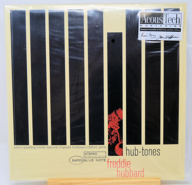 Acous Tech Mastering 'hub-tones' album vinyl record sleeve for 'freddie Hubbard', featuring a cream-colored background with vertical black stripes and a red graphic, photographed in its plastic shrink wrap.