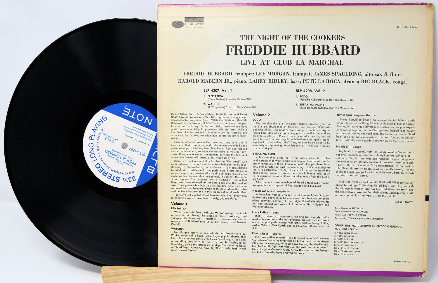 Vinyl record with cover displaying text and a blue label on a white background