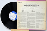Vinyl record with cover displaying text and a blue label on a white background