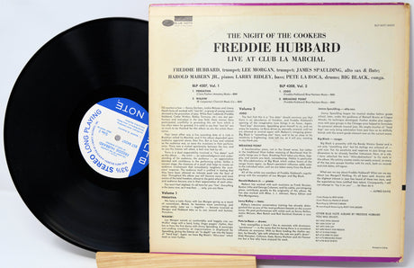 Vinyl record with cover displaying text and a blue label on a white background