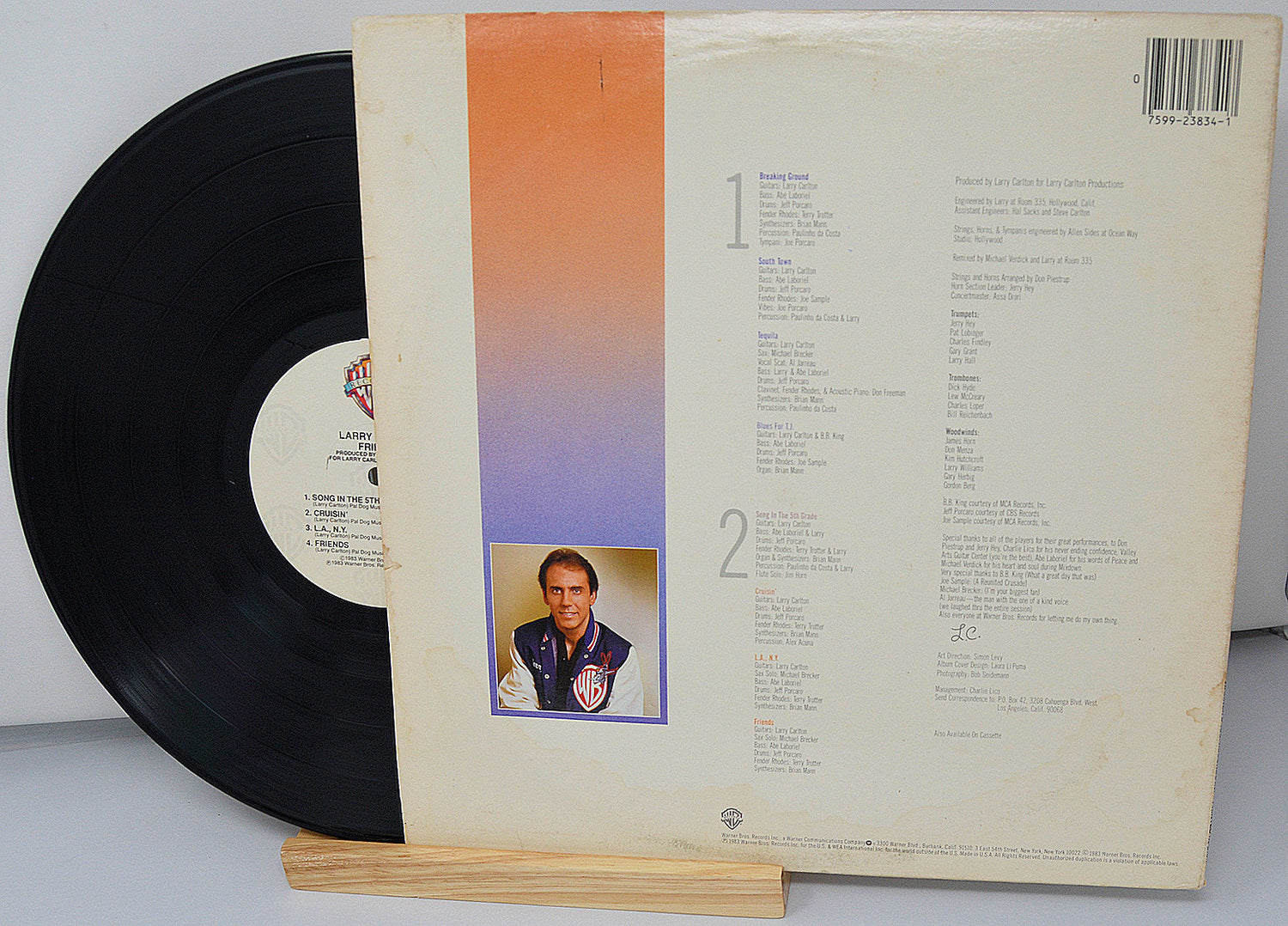 Back cover of Larry Carlton's Friends vinyl LP showing song list, credits, and a photo of the artist