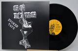 Vinyl record with black cover featuring artistic design and yellow label on a gray background