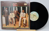 Vinyl record with cover featuring a group of men in suits.