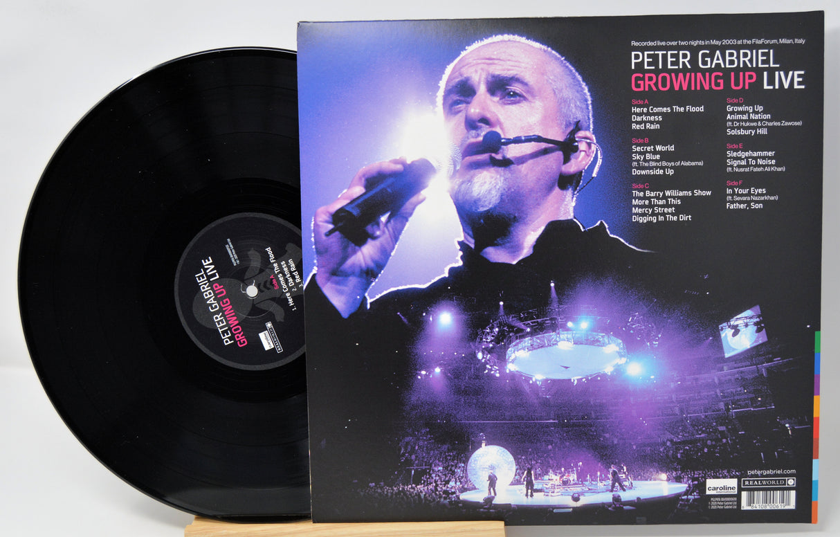 Vinyl record and cover of Peter Gabriel's 'Growing Up Live' album on a white background