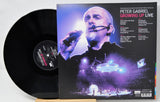 Vinyl record and cover of Peter Gabriel's 'Growing Up Live' album on a white background