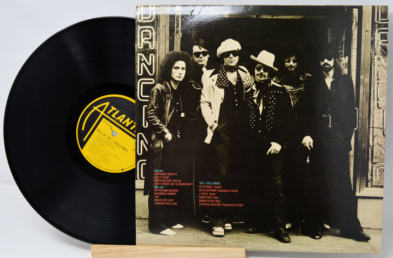 Vinyl record with a cover featuring a group of people, including a prominent yellow label.