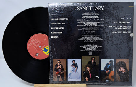 Vinyl record with cover featuring album tracklist and promotional images on a light gray background